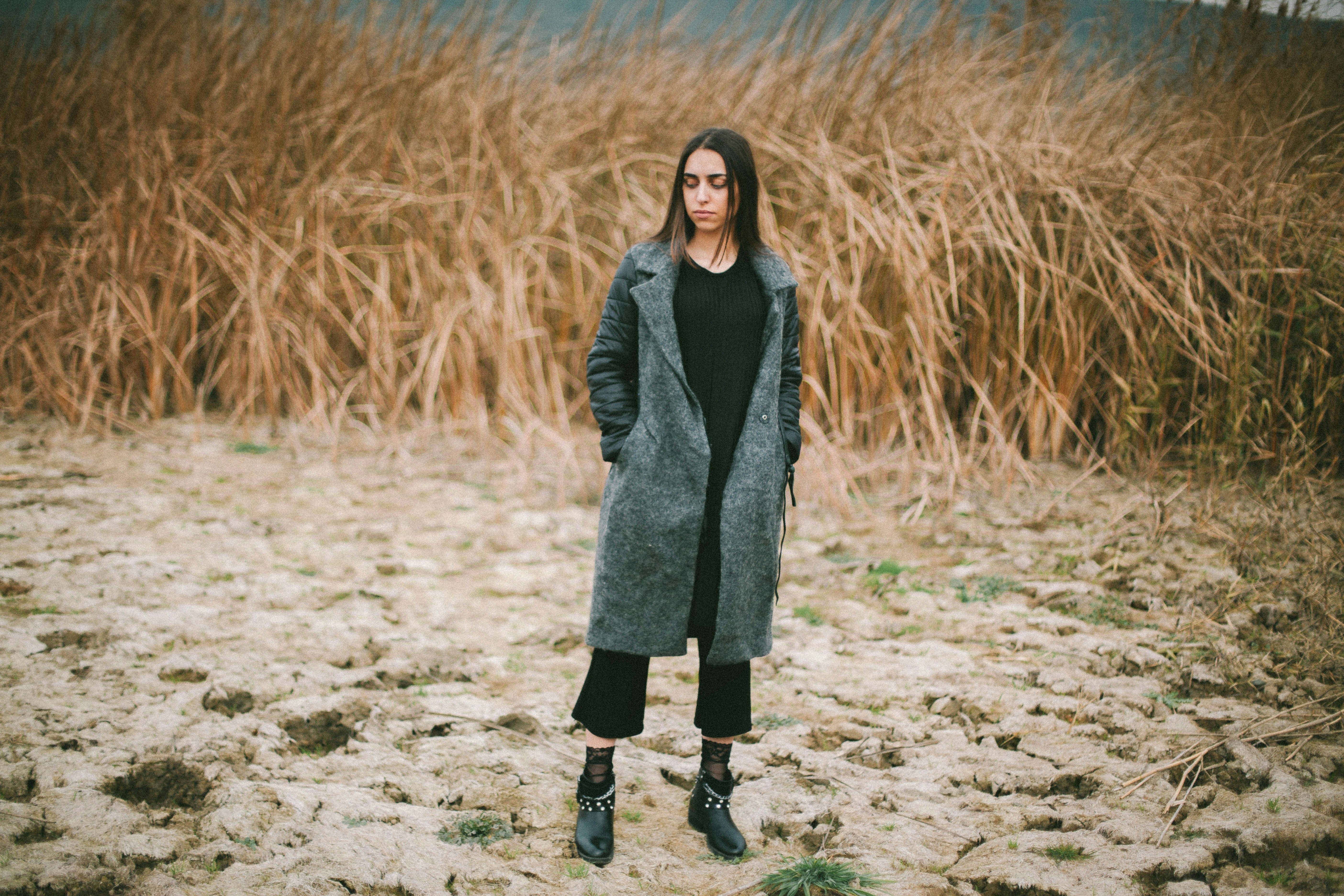 woman standing in front of dried plants